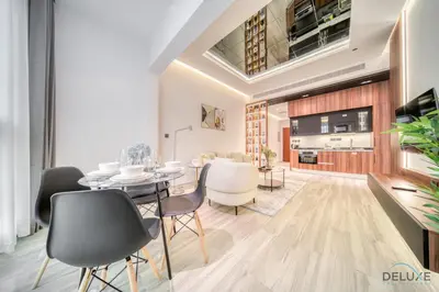 a dining room and living room with a table and chairs at Modern 1BR at Marina Park Dubai Marina by Deluxe Holiday Homes in Dubai