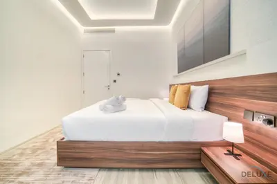 a bedroom with a white bed with a stuffed animal on it at Modern 1BR at Marina Park Dubai Marina by Deluxe Holiday Homes in Dubai