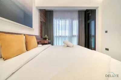 a bedroom with a large white bed with yellow pillows at Modern 1BR at Marina Park Dubai Marina by Deluxe Holiday Homes in Dubai
