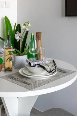 a white table with a plate and wine bottles on it at Frank Porter - Oxford 212 in Dubai