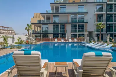 a swimming pool with lounge chairs and a building at Frank Porter - Oxford 212 in Dubai