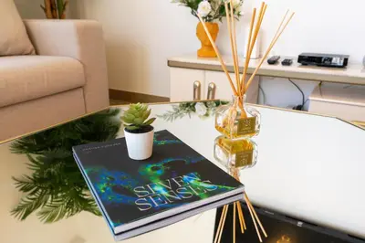 a glass coffee table with a book on it at Ultimate Stay Port de La Mer with Burj Khalifa Views from the Bed next to the Beach in Dubai