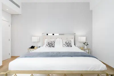 a bedroom with a large white bed with two lamps at Ultimate Stay Port de La Mer with Burj Khalifa Views from the Bed next to the Beach in Dubai