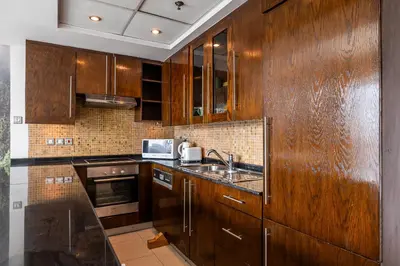 a kitchen with wooden cabinets and a sink at Spacious Studio in Downtown I 8 Boulevard Walk in Dubai