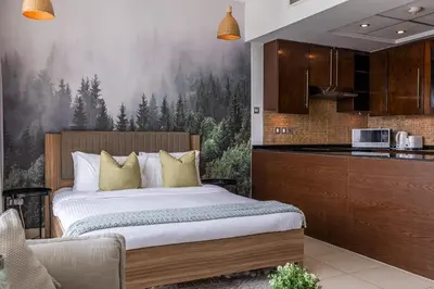 a bedroom with a large bed and a kitchen at Spacious Studio in Downtown I 8 Boulevard Walk in Dubai