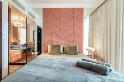 a bedroom with a large bed with a pink wall at Triplex Paradise Penthouse in Dubai