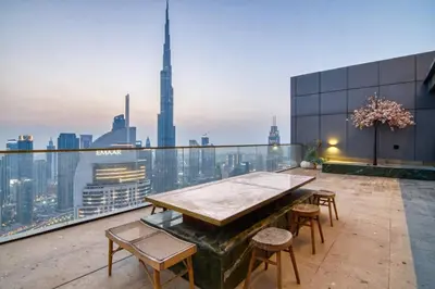 a balcony with a table and chairs on a building at Triplex Paradise Penthouse in Dubai