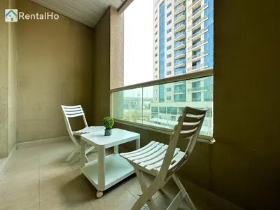 two chairs and a table in a room with a window at Quiet Studio with Balcony and Roof Top Pool in Dubai Marina in Dubai