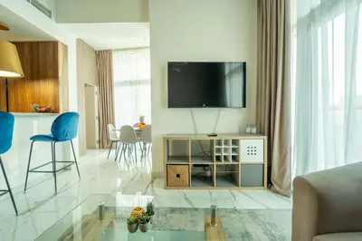 a living room with a tv on a wall at AWS Holiday Homes - Luxurious 2BR in Business Bay in Dubai