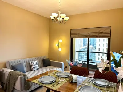 a living room with a table and a couch at La buena vida holiday homes - Deluxe 3 bedroom apartment on the beach in Dubai
