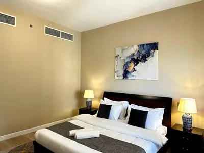 a bedroom with a large bed with two lamps at La buena vida holiday homes - Deluxe 3 bedroom apartment on the beach in Dubai