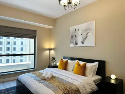 a bedroom with a large bed with a window at La buena vida holiday homes - Deluxe 3 bedroom apartment on the beach in Dubai