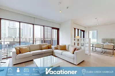 a living room with two white couches and a table at Sunset at Creek Beach - Exquisite Two Bedroom in Dubai