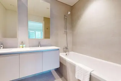 a bathroom with a white tub and a sink and a bath tubermottermottermott at Sunset at Creek Beach - Exquisite Two Bedroom in Dubai