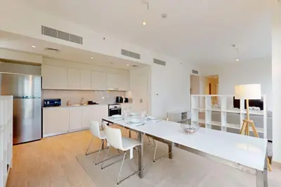 a large white kitchen with a long table and chairs at Sunset at Creek Beach - Exquisite Two Bedroom in Dubai
