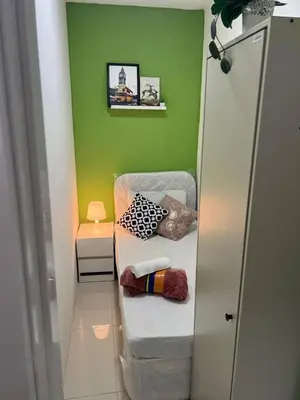 a small room with a bed and a green wall at Best Closed Partition Room in Al Barsha-1 Near MOE Metro in Dubai