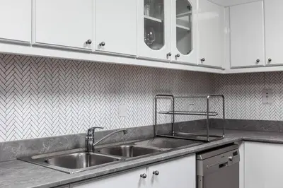 a kitchen with a stainless steel sink and white cabinets at 2 BDR in Marina Terrace Dubai Marina in Dubai