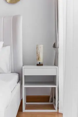 a white nightstand next to a bed and a white couch at 2 BDR in Marina Terrace Dubai Marina in Dubai