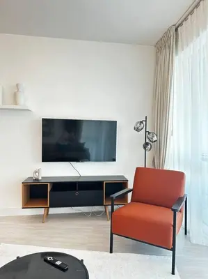 a living room with a tv and a red chair at 2 BDR in Marina Terrace Dubai Marina in Dubai