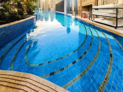 a large swimming pool with blue water in a building at Magnificent apartment in Emaar Dubai Marina in Dubai