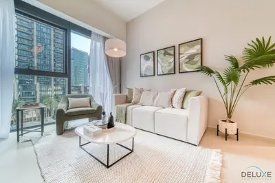 a living room with a white couch and a palm tree at Sumptuous 1BR at Act One Act Two Tower 1 Downtown Dubai by Deluxe Holiday Homes in Dubai