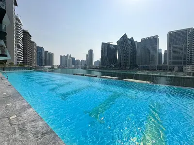 a large swimming pool with a city skyline in the background at Trophy Sunny Honey Suite Canal View & Infinty Pool in Dubai