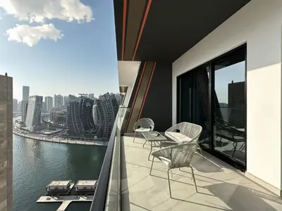 a balcony with chairs and a view of the water at Trophy Sunny Honey Suite Canal View & Infinty Pool in Dubai