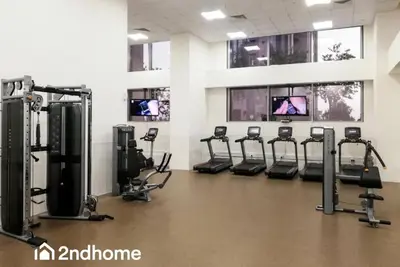 a gym with treadmills and machines in a room at 2ndHome - Amna Tower, Al Habtoor City in Dubai