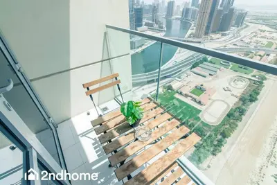 a wooden bench sitting on top of a glass building at 2ndHome - Amna Tower, Al Habtoor City in Dubai