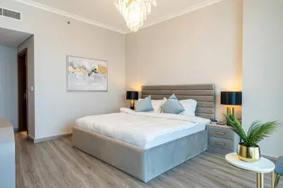 a bedroom with a large bed and a chandelier at Downtown 3BR Luxe, Burj & Fountain View Bliss Near Dubai Mall in Dubai