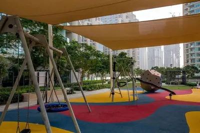 a playground in a city with a slide and swings at Downtown 3BR Luxe, Burj & Fountain View Bliss Near Dubai Mall in Dubai