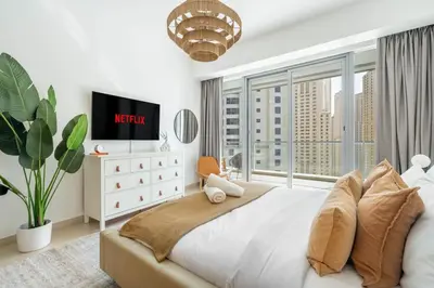 a bedroom with a large bed with a large window at GuestReady - Lux home with sea view balcony in Dubai