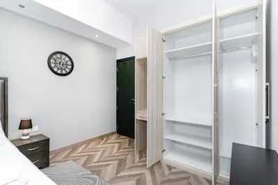 a bedroom with a closet and a clock on the wall at Group Stay I Near Dubai Mall I Family friendly in Dubai