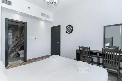 a white room with a table and a clock on the wall at Group Stay I Near Dubai Mall I Family friendly in Dubai