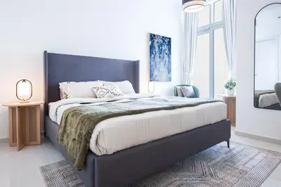 a bedroom with a large bed with a black headboard at Elite LUX Holiday Homes - Serene Golf View Living 1 BHK in Damac Hills, Dubai in Dubai