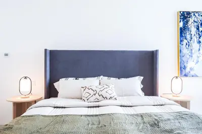 a bedroom with a large bed with two lamps at Elite LUX Holiday Homes - Serene Golf View Living 1 BHK in Damac Hills, Dubai in Dubai