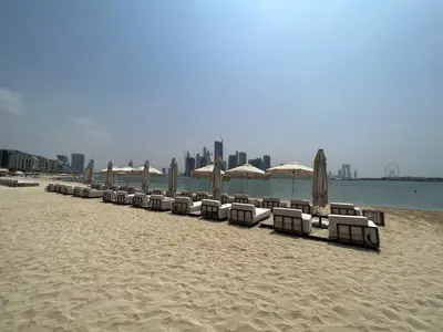 a row of beach chairs and umbrellas on a beach at Chic Palm Studio with Sea View & Infinity Pool in Dubai