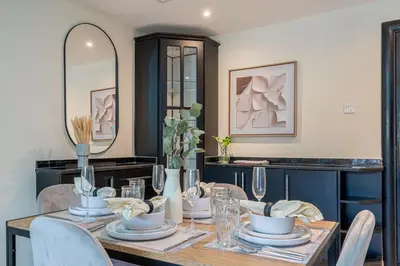 a dining room with a table with chairs and a mirror at Stunning 1 BR Apartment with Pool View in JVC Dubai in Dubai