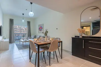 a kitchen and dining room with a table and chairs at Stunning 1 BR Apartment with Pool View in JVC Dubai in Dubai