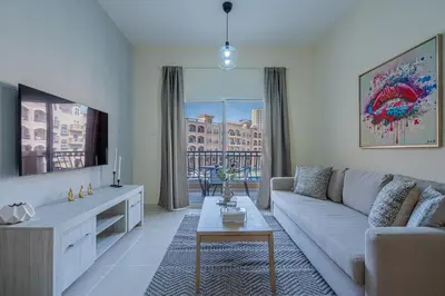 a living room with a couch and a tv at Stunning 1 BR Apartment with Pool View in JVC Dubai in Dubai
