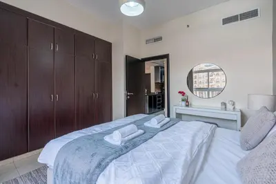 a bedroom with a large bed with two towels on it at Stunning 1 BR Apartment with Pool View in JVC Dubai in Dubai