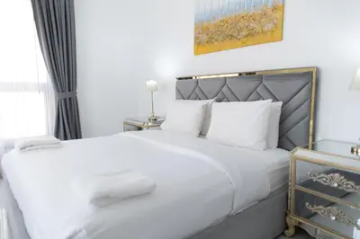 a white bedroom with a large bed with white pillows at MURJAN JBR Apartments by HAPPY SEASON in Dubai