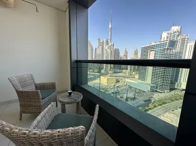 a balcony with chairs and a view of a city at Manzil - Cozy Studio nr Downtown w Canal Views in Dubai