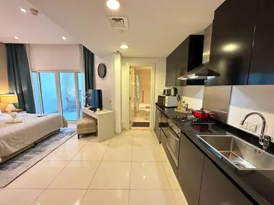 a kitchen with a sink and a bed in a room at Manzil - Cozy Studio nr Downtown w Canal Views in Dubai