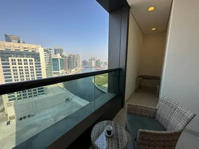 a room with a balcony with a view of a city at Manzil - Cozy Studio nr Downtown w Canal Views in Dubai