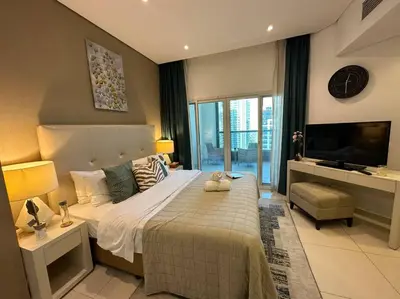 a bedroom with a large bed and a television at Manzil - Cozy Studio nr Downtown w Canal Views in Dubai
