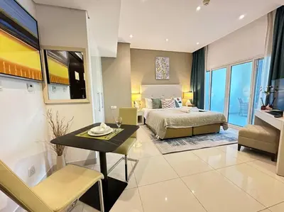 a bedroom with a bed and a table in a room at Manzil - Cozy Studio nr Downtown w Canal Views in Dubai