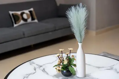 a white vase sitting on a table with a plant at Furnished Apartment for Rent in Saba 3, JLT in Dubai