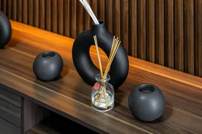 a table with black vases and a glass jar with chopsticks at Furnished Apartment for Rent in Saba 3, JLT in Dubai