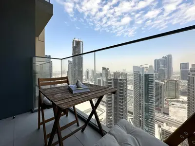 a table on a balcony with a view of a city at Trophy - Downtown Skyview Residence in 35th floor in Dubai